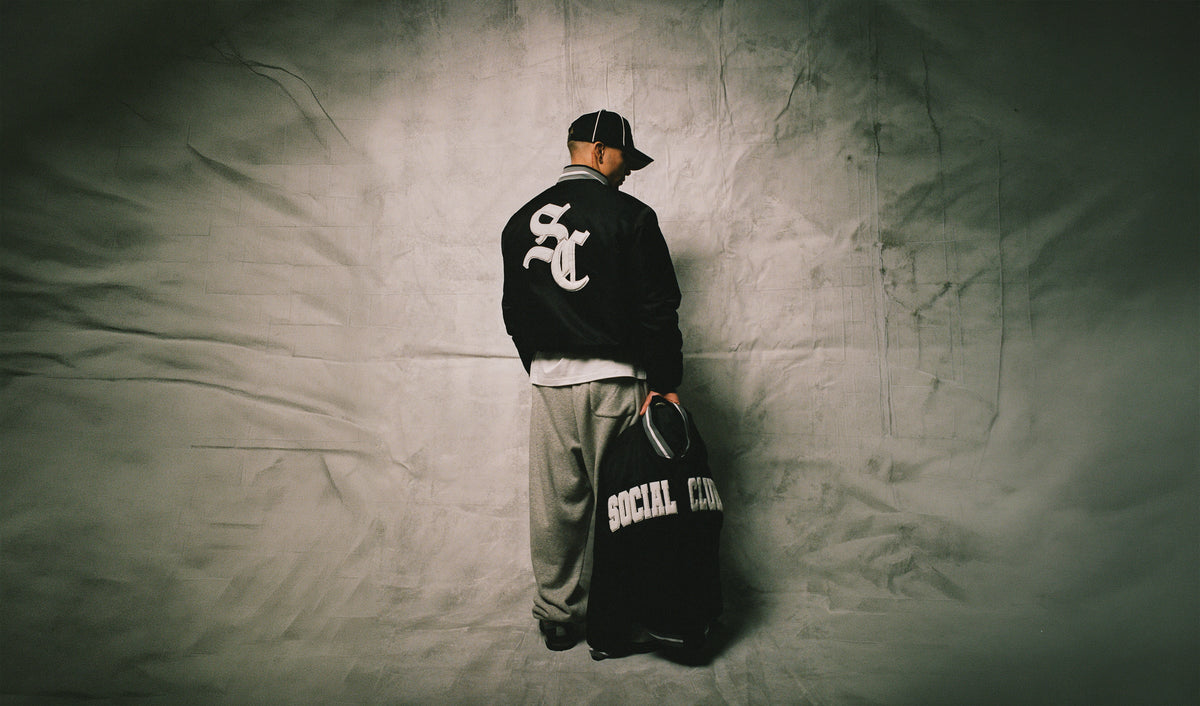 Julian in the Social Club Stadium Varsity Jacket and Butter-Soft sweats